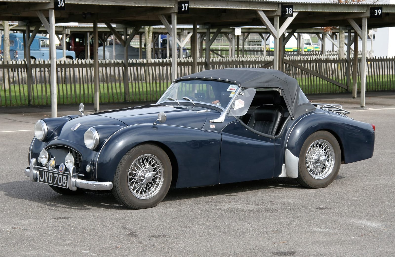 A dark blue Triumph TR2 with a hardtop fitted, front three-quarter view
