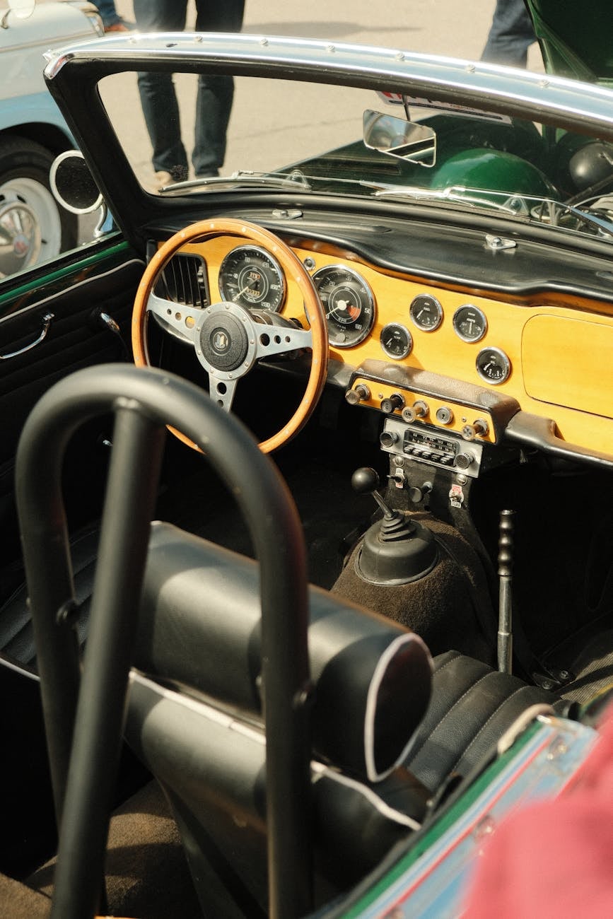 The interior of a Triumph TR4, showing the wooden dashboard and wood-rimmed steering wheel