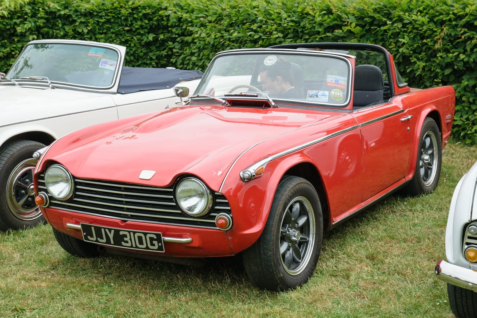 A red Triumph TR5, front three-quarter view on grass