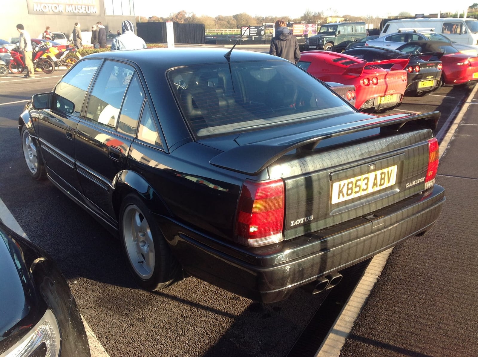 The rear three-quarter of a dark green Lotus Carlton with boot spoiler, UK registration K853 ABV