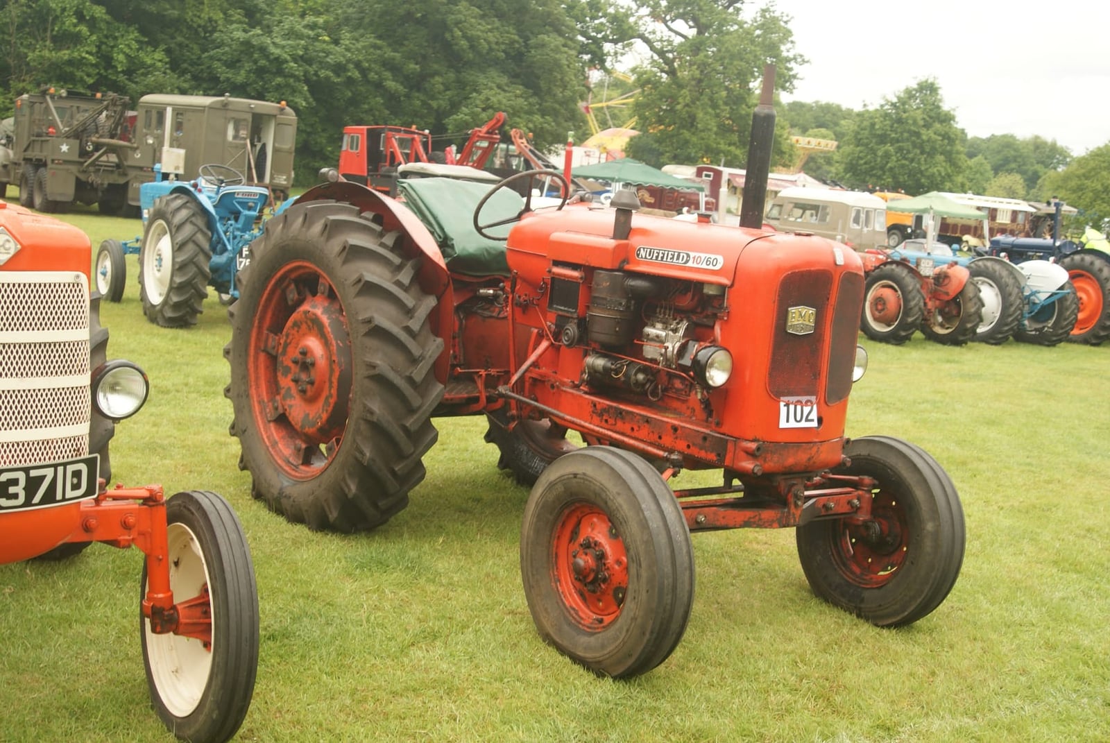 An orange Nuffield DM4 at the St Albans steam and country show, other tractors lined up behind